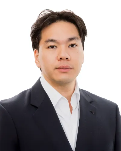 Professional headshot of a man wearing a black suit jacket and white dress shirt against a white background