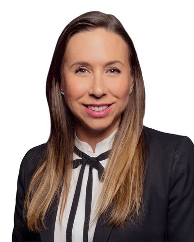 Smiling woman with long brown hair in business attire against a white background.