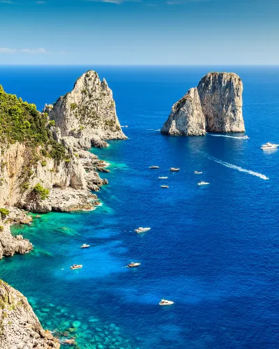 a body of water with boats in it and rocky cliffs around it