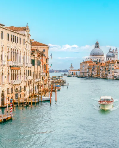 a river with boats in it and buildings around it with Grand Canal in the background