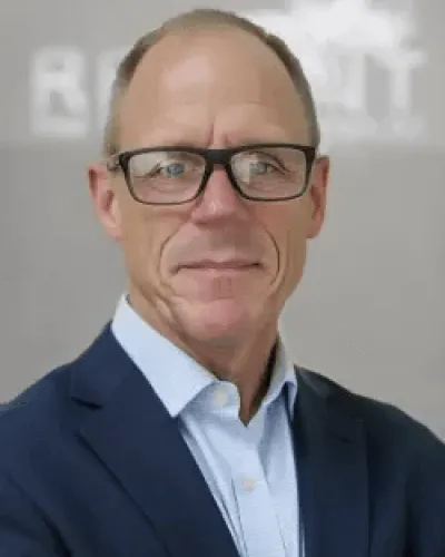 Professional middle-aged man with glasses wearing a blue suit and light blue shirt against a gray background.