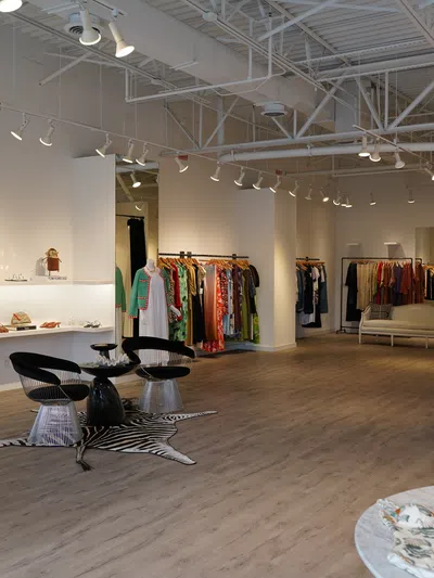 Modern boutique interior with clothing racks, mannequins, shoes, accessories, and stylish seating area.