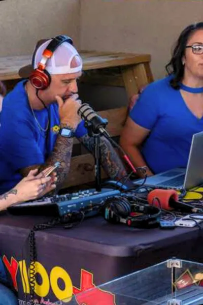 a group of people sitting at a table with microphones and a laptop