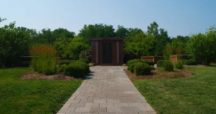 a brick pathway with grass and trees