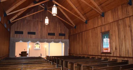 a large wooden church with wood benches
