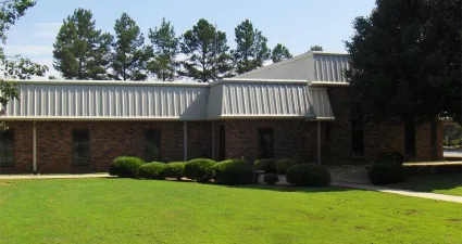 a brick building with a green lawn