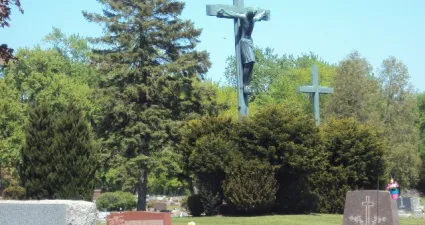 a statue of a person holding a cross