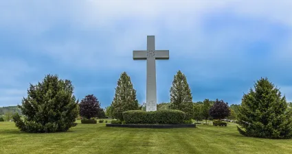 a cross on a grassy hill