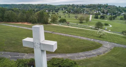 a white cross in a cemetery