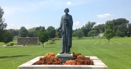 a statue of a person in a green field
