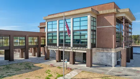 Modern brick and glass courthouse building with an American flag on a sunny day.