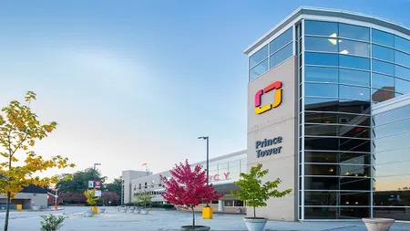 Modern Prince Tower building with colorful trees and clear blue sky at sunrise or sunset.