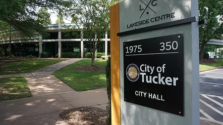 Signage for City of Tucker City Hall at Lakeside Centre with walkway, trees, and building in background