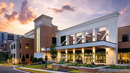 Modern hospital building with Welstar signage during sunset and landscaped grounds in the foreground