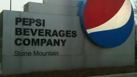 Pepsi Beverages Company Stone Mountain sign with large Pepsi logo beside a concrete structure outdoors.