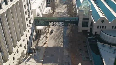 Aerial view of the Fulton County Justice Center and Courts connected by a skybridge over an empty street in daytime.