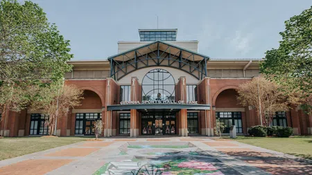 Front entrance of Georgia Sports Hall of Fame with brick facade and decorative pavement artwork under clear sky.