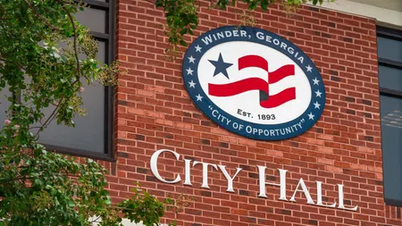 Winder, Georgia City Hall building with red brick exterior and city seal featuring flag and star.