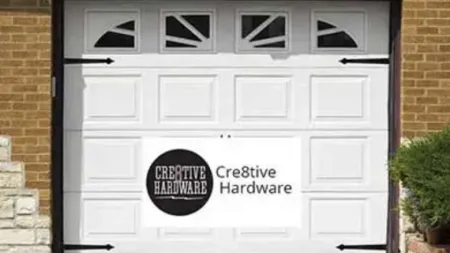 White garage door with black hardware accents and a sign reading Cre8tive Hardware in black and white.