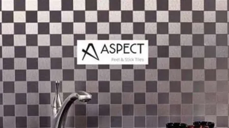 Modern kitchen wall with black and silver peel and stick checkerboard tiles behind a faucet and decorative cups