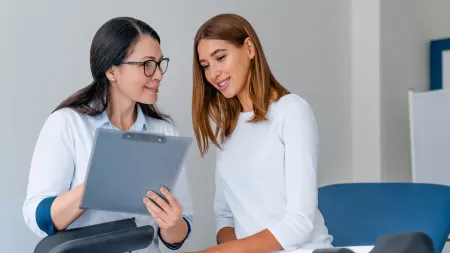 a woman showing a laptop to another woman