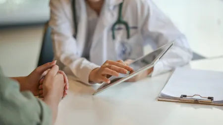 a man and a woman looking at a laptop