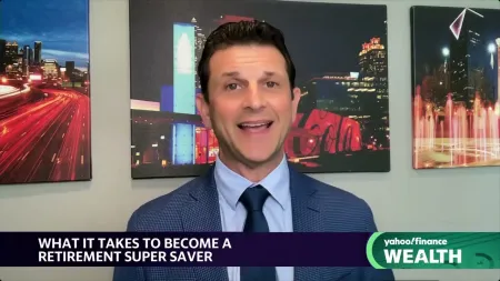 Man in blue suit and tie speaking on Yahoo Finance Wealth with cityscape artwork in background