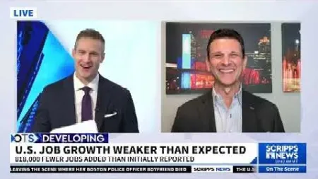 Two news anchors smiling during a live broadcast about U.S. job growth being weaker than expected.