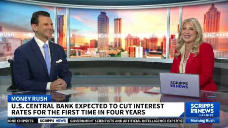 Two news anchors discussing U.S. central bank interest rate cuts on Scripps News Morning Rush show.