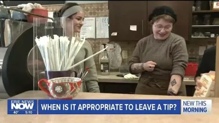 Two smiling women behind a coffee shop counter with straws and a decorative cup in front