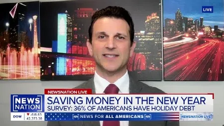 News anchor discusses saving money in the new year with graphics of cityscapes at night behind him.