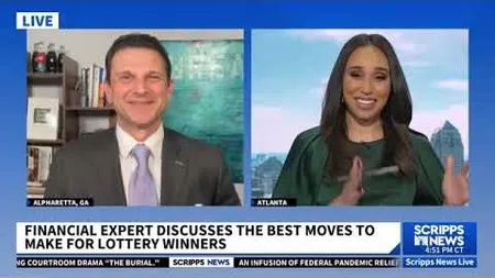 Two news anchors discussing financial advice for lottery winners during a live Scripps News broadcast.