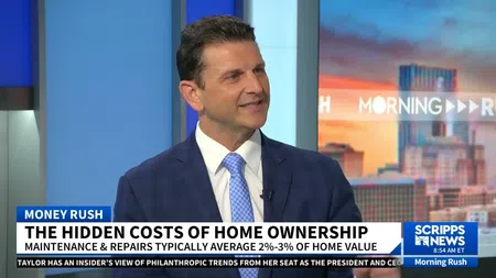 Man in blue suit discussing hidden costs of home ownership on a news show set