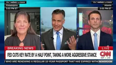 CNN broadcast showing three anchors discussing Fed's half-point key rate cut and aggressive stance.