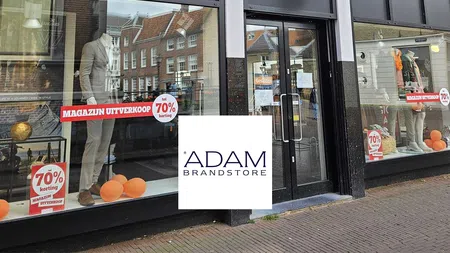 Adam by Duetz clothing store storefront with mannequins and signs for 70% off sale in Dutch