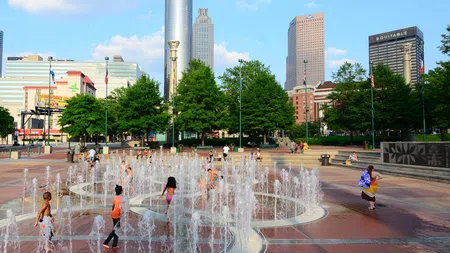 a group of people playing in a water fountain in Centennial Olympic Park