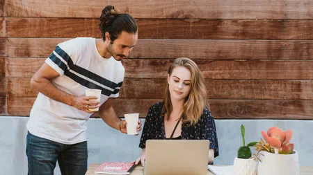 a man and a woman looking at a laptop