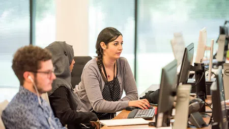 a woman and a man looking at a computer screen