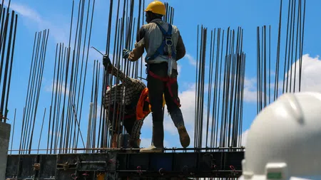 a man wearing a hard hat and climbing a metal structure