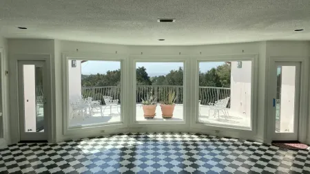 a room with a large window and a rug in it
