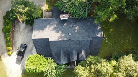 a black house with a car parked in the driveway