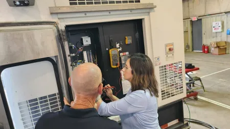 Technicians inspecting and repairing HVAC equipment in a commercial setting.