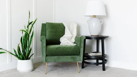 wool cream carpet with a green chair next to a lamp