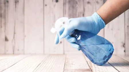 a person wearing gloves, cleaning, spray bottle