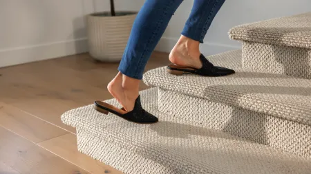 a person wearing shoes and walking on carpet up stairs