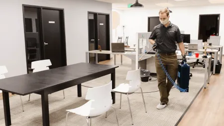 a person standing in a room with tables and chairs