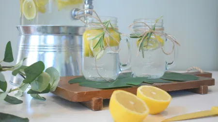 a group of glass jars with lemons and a lemon on a cutting board