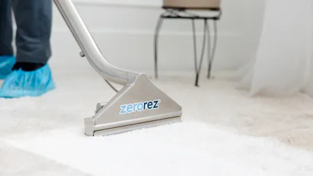 a Zerorez Zr Wand extracting dirt and stains with water on a white carpet with water stain spots