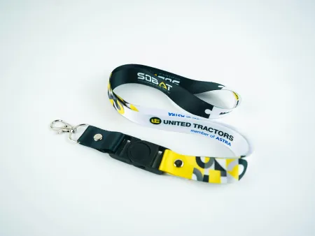 Black and white United Tractors lanyard with yellow accents and metal clip on a white background.