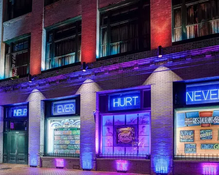 House of Blues building lit with purple and blue lights with overlaid text reading HELP EVER HURT NEVER